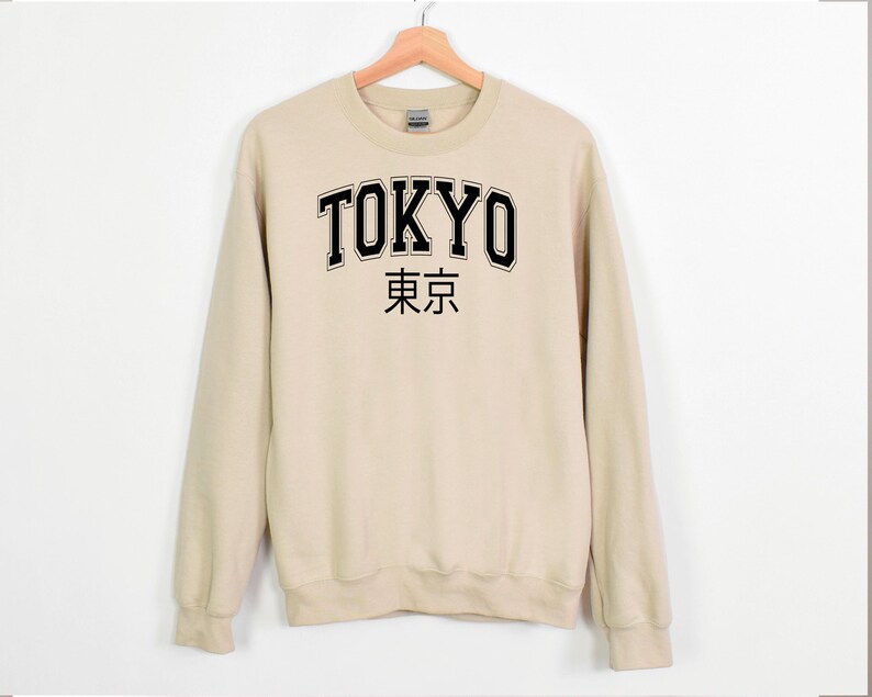 May include: A beige sweatshirt with black text that reads "TOKYO" and "東京" in Japanese.