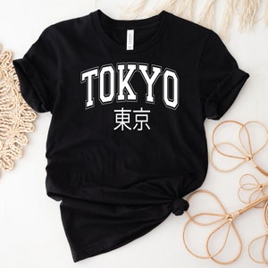 K&ouml;nnte beinhalten: Schwarzes T-Shirt mit wei&szlig;em Text "TOKYO" und den japanischen Schriftzeichen f&uuml;r Tokio.