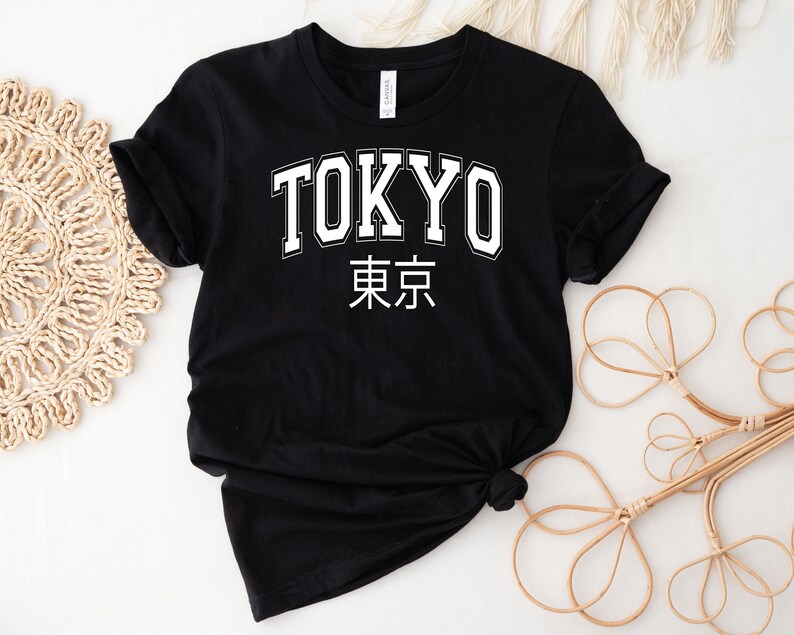 K&ouml;nnte beinhalten: Schwarzes T-Shirt mit wei&szlig;em Text "TOKYO" und den japanischen Schriftzeichen f&uuml;r Tokio.