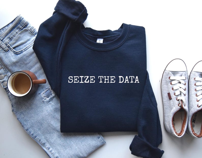 K&ouml;nnte beinhalten: Ein marineblauer Pullover mit dem Text "SEIZE THE DATA" in wei&szlig;en Buchstaben.