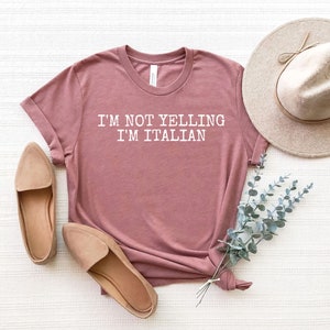May include: A mauve t-shirt with the text "I'm not yelling I'm Italian" printed in white.