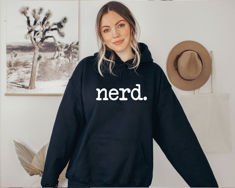 K&ouml;nnte beinhalten: Schwarzer Kapuzenpullover mit dem Wort "Nerd" in wei&szlig; auf der Vorderseite.