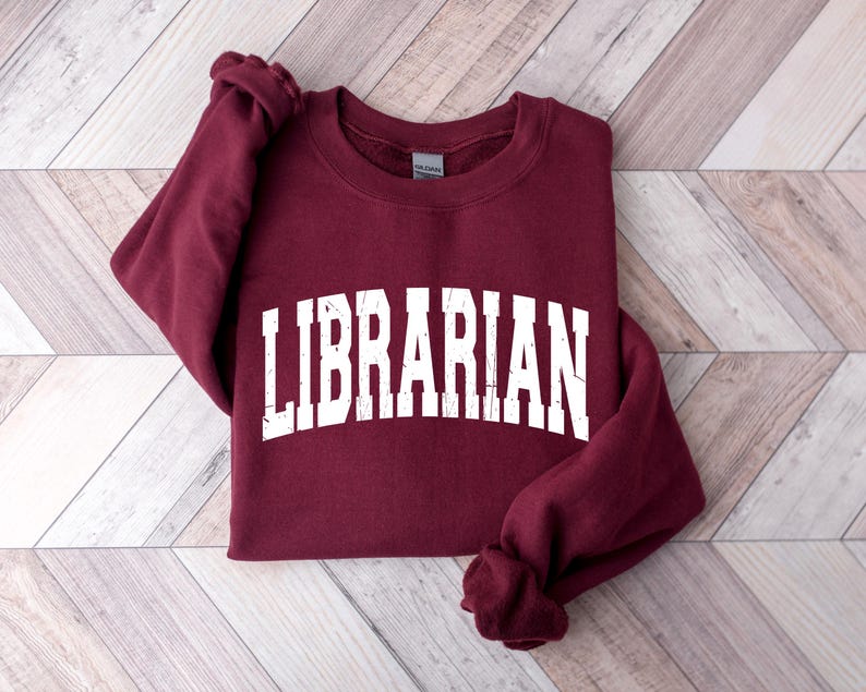 May include: A maroon sweatshirt with the word "LIBRARIAN" printed in white on the front.
