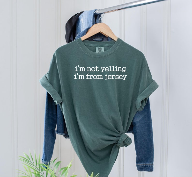 May include: A green t-shirt with the text "i'm not yelling i'm from jersey" in white lettering.