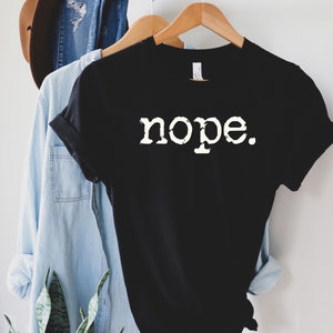 May include: Black t-shirt with white text that reads "nope."