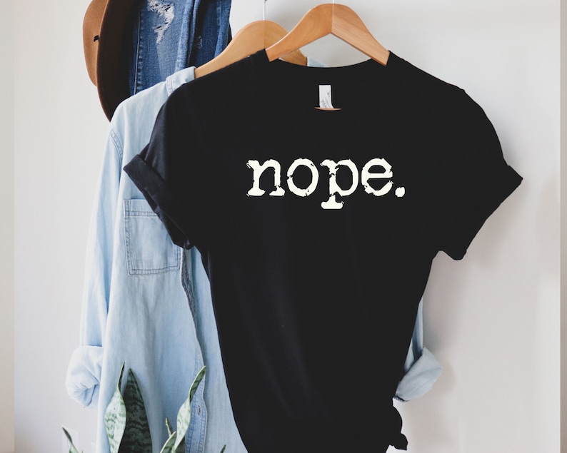May include: Black t-shirt with white text that reads "nope."