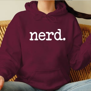 K&ouml;nnte beinhalten: Burgunderfarbener Hoodie mit einem wei&szlig;en "Nerd." Aufdruck.