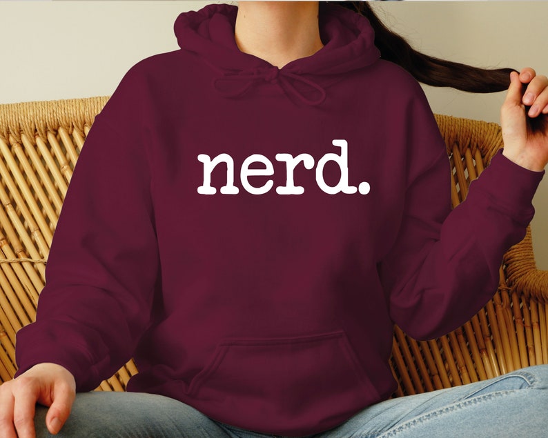 K&ouml;nnte beinhalten: Burgunderfarbener Hoodie mit einem wei&szlig;en "Nerd." Aufdruck.