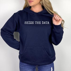 K&ouml;nnte beinhalten: Ein marineblauer Hoodie mit einem wei&szlig;en Aufdruck, der "Seize the Data" lautet.