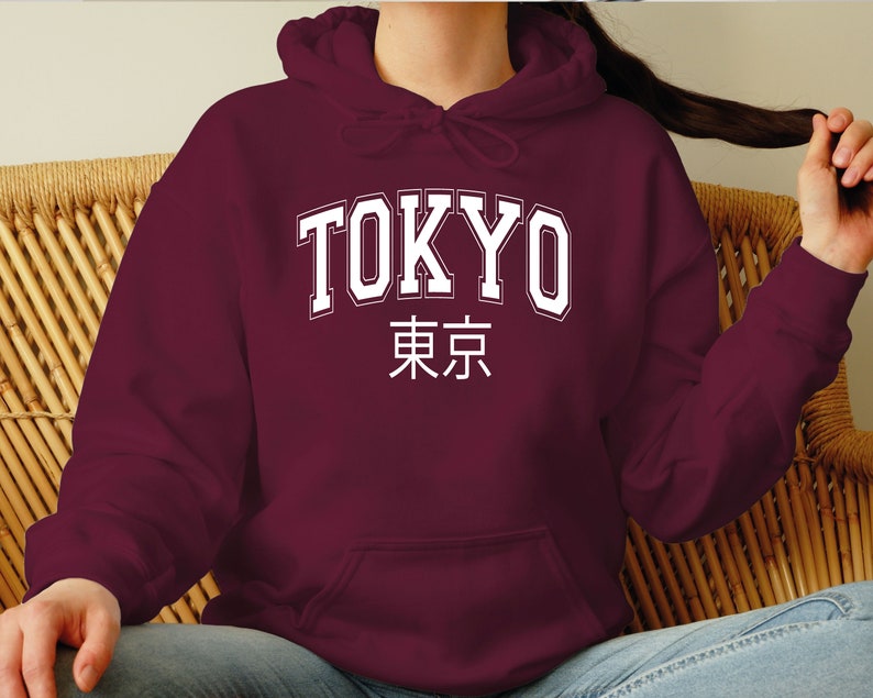 May include: A maroon hoodie with a white print that says "TOKYO" in a collegiate font and "東京" in Japanese characters.