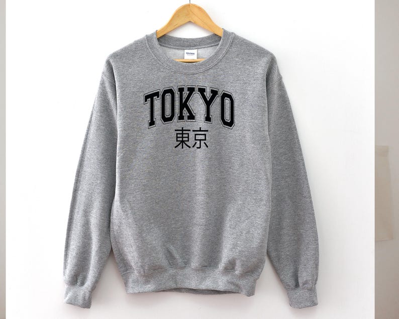 May include: A grey sweatshirt with the word "TOKYO" in black lettering and the Japanese characters for "Tokyo" underneath.