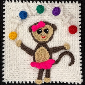 May include: A crocheted square featuring a brown monkey with a pink bow and tutu, juggling colorful balls. The monkey is centered on a white background with a black border, showcasing a playful design.