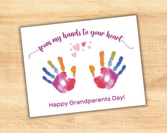 Puede incluir: Tarjeta blanca con huellas de manos coloridas y texto. La frase "from my hands to your heart" está sobre dos huellas de manos. Debajo, el texto dice "Happy Grandparents Day!" en púrpura.