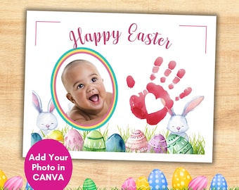 Puede incluir: Tarjeta de Pascua con el texto "Happy Easter" en escritura rosa. La tarjeta presenta la foto de un bebé en un marco ovalado colorido, una huella de mano roja con un recorte de corazón e ilustraciones de acuarela de huevos y conejitos de Pascua. La parte inferior de la tarjeta tiene el texto "Add Your Photo in CANVA".