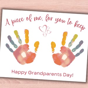 May include: A white card with a handprint design in pink, orange, yellow, and blue. The card says "A piece of me, for you to keep" and "Happy Grandparents Day!" with pink hearts.