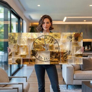 Può includere: Un orologio da parete rettangolare con un design a mosaico oro e bianco. Il quadrante dell'orologio è nero con numeri romani. Le lancette dell'orologio sono argentate. L'orologio è tenuto da una persona.