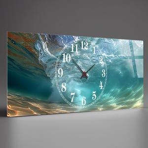 Puede incluir: Reloj de pared rectangular con un diseño de ola oceánica. La esfera del reloj es blanca con manecillas y números negros. El fondo muestra una ola turquesa con tonos arenosos, creando una pieza dinámica y artística.