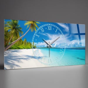 May include: A rectangular wall clock featuring a tropical beach scene with palm trees, white sand, and turquoise water under a blue sky. The clock face is a transparent overlay with Roman numerals and silver hands.
