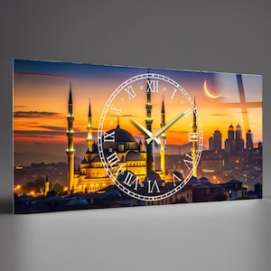 May include: A rectangular wall clock featuring a sunset view of a mosque with minarets and a crescent moon. A white clock face with Roman numerals and gold hands is superimposed over the image. The clock has a glass-like appearance.