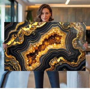 May include: A rectangular wall art piece featuring a geode design. The artwork showcases a central cavity with sparkling crystals, surrounded by layers of black, gold, and amber-colored bands. The overall aesthetic is luxurious and decorative.