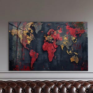 May include: A rectangular world map print with a distressed, textured finish. Continents are depicted in red and gold against a dark grey backdrop. The artwork is mounted on a wall above a brown leather sofa.