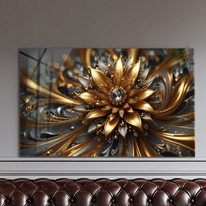 May include: A decorative wall art piece featuring a detailed, golden flower design with silver and black accents. The artwork has a central jewel and is set against a gray background, creating a luxurious aesthetic.