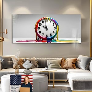 Puede incluir: Una impresión de arte mural rectangular que presenta un reloj con una esfera blanca y números negros. El marco del reloj es un arcoíris de colores, con pintura goteando. El texto "DUTIES AND TAXES PAID FOR U.S. BUYERS" es visible.