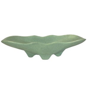 May include: A light green, mid-century modern ceramic dish with a unique, elongated shape. The dish has a textured surface and three small feet. The wavy design adds a touch of elegance to this decorative piece, perfect for displaying small items or as a standalone art object.