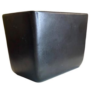 May include: A solid black, square-shaped object with rounded corners. The object has a smooth, matte finish and appears to be made of a durable material. The design is simple and modern, suitable for various uses.