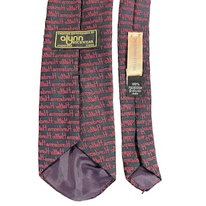 May include: A black and red patterned tie with the text "Hello Handsome" repeated throughout. The tie has a label that reads "Creative Expressions by Alynn Neckwear, Stamford, Conn." and another label that reads "100% Polyester, Alynn, 1982."