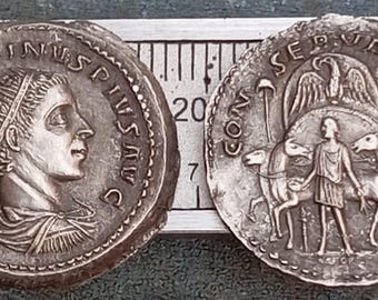 May include: Two silver Roman coins with Latin inscriptions. The obverse coin features a portrait of a Roman emperor with the inscription "IMP  ANTONINVS  PIVS  AVG". The reverse coin features an eagle with the inscription "CON  SEPV  HOR  AVG".
