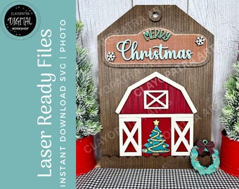 May include: Wooden Christmas decoration featuring a red barn with white trim and a teal Christmas tree. The sign above reads "Merry Christmas" in teal lettering. The background is a wood grain pattern.