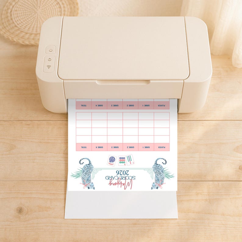 K&ouml;nnte beinhalten: Ein beigefarbener Desktop-Drucker, der ein wei&szlig;es Blatt Papier mit einer Mahjong-Punktetabelle f&uuml;r 2026 ausgibt. Die Karte enth&auml;lt ein Raster zur Punkteverfolgung, Illustrationen von zwei blau gemusterten Katzen und kleine Mahjong-Kacheln.
