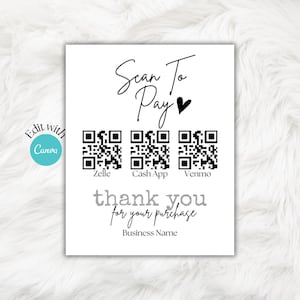 May include: A white sign with black text that reads "Scan To Pay" with a heart symbol. There are three QR codes with the names "Zelle", "Cash App", and "Venmo" below them. The text "thank you for your purchase" and "Business Name" are at the bottom of the sign.