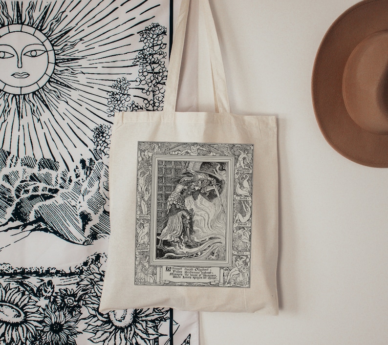 May include: A white tote bag with black and white illustration of a knight fighting a dragon. The illustration is framed with a black border and includes the text "The Dragon's Oath: When the Sword is Unsheathed, the Dragon's Fury is Unleashed."