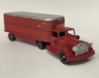 Może przedstawiać: Miniaturowy model czerwonej ciężarówki z naczepą, srebrnym dachem i srebrnym grillem. Ciężarówka posiada czarne koła z pomarańczowymi środkami oraz długą naczepę przymocowaną do kabiny. Poniżej widoczny jest tekst Digital STLs - Ready To 3D Print.