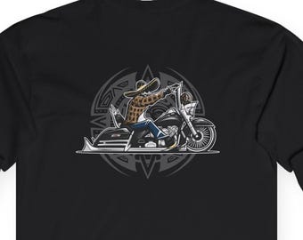 Könnte beinhalten: Schwarzes Langarmshirt mit einer Grafik einer Person, die Motorrad fährt. Die Illustration ist in Grau-, Braun- und Blautönen gehalten. Das Design ist vor einem kreisförmigen Emblem platziert.