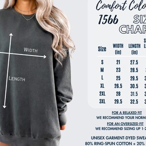 May include: A dark gray unisex garment-dyed sweatshirt with a size chart. The chart shows width, length, and sleeve length measurements in inches for sizes S to 3XL. The sweatshirt is 80% ring-spun cotton and 20% polyester.