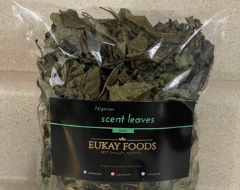 May include: A clear plastic bag filled with dried Nigerian scent leaves. The bag has a black label with white text that reads "Nigerian scent leaves Dried EUKAY FOODS BEST QUALITY, ALWAYS". The leaves are green and brown.