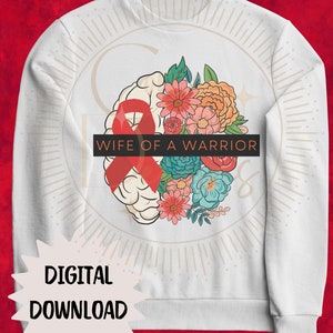 May include: White sweatshirt with a red ribbon and flowers design. The text "Wife of a Warrior" is printed on the sweatshirt.