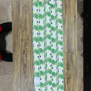 May include: Three white shoelaces with a green and white pattern of 100 euro bills.