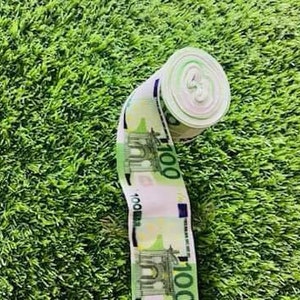 Puede incluir: Un rollo de cinta decorativa con un patrón repetido de billetes de 100 euros. La cinta es blanca con acentos azules y verdes.