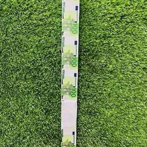 May include: A long strip of paper with images of 100 Euro bills printed on it. The paper is white with a green background and the bills are printed in blue and green.