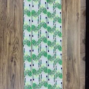 May include: Four white fabric strips with a repeating pattern of 100 euro bills printed on them.
