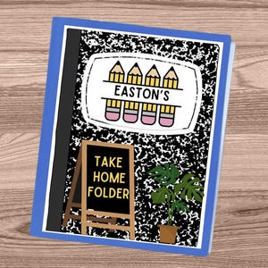May include: A composition notebook with a blue border and a black and white speckled design. The notebook features a white label with yellow pencils and the text "EASTON'S". Below the label is a small chalkboard that reads "TAKE HOME FOLDER". A potted plant is also visible.
