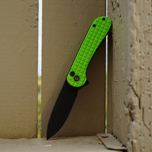 May include: A green pocket knife with a black blade and a textured green handle.