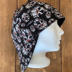 May include: Black and white skull print welding cap with a red splatter design. The cap is made of a soft, comfortable fabric and has a fleece lining for warmth.