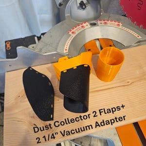 K&ouml;nnte beinhalten: Ein Set aus orangefarbenen und schwarzen Staubabsaugungszubeh&ouml;r f&uuml;r eine S&auml;ge. Das Set enth&auml;lt einen Staubabscheider mit zwei Klappen und einen 5,7 cm Vakuumadapter. Der Text "Dust Collector 2 Flaps+ 2 1/4" Vacuum Adapter" ist aufgedruckt.