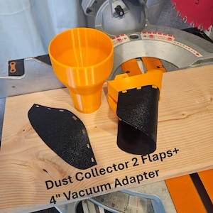 K&ouml;nnte beinhalten: Ein orangefarbener, 3D-gedruckter Staubabscheider mit zwei schwarzen Klappen und einem 10,16 cm Vakuumadapter. Der Text "Dust Collector 2 Flaps+ 4" Vacuum Adapter" ist auf die Holzoberfl&auml;che gedruckt. Ein rotes S&auml;geblatt ist sichtbar.