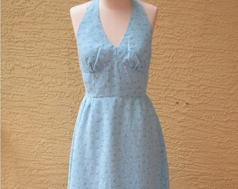 May include: A light blue halter dress with a floral print and a ruffled hem.
